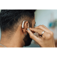 man adjusting hearing aid